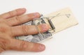 A man& x27;s hand fell into a mousetrap with dollar bills for bait. Royalty Free Stock Photo