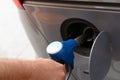 Man`s hand fills his car`s fuel tank with gasoline hose