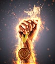 Man`s hand in a fire is holding up gold medal. Winner in a competition. Royalty Free Stock Photo