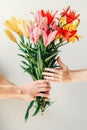 Man`s hand giving bouquet of flowers to woma`s hand on white background