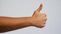 Man\'s hand giving a thumbs up against a plain background representing a positive gesture Royalty Free Stock Photo