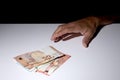 Man`s hand grabbing some Euro banknotes with copy space for your text