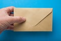 Man`s hand hold envelope  on blue background Royalty Free Stock Photo