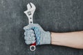 Man hand holding an adjustable spanner wrench on gray background Royalty Free Stock Photo