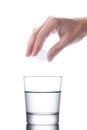 Man`s hand holding an aspirin pill dropping it in a water of glass isolated on white background with clipping path included Royalty Free Stock Photo