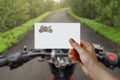 Man's hand holding bike symbol paper on road. Concept of journey, travel, dream, freedom.