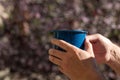A man`s hand  holding  a  blue coffee cup Royalty Free Stock Photo