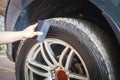 Man's hand holding a blue fabric cleaning car tires and wheels Royalty Free Stock Photo