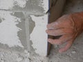 A man`s hand holding on a blue string, established by the use of a plumb bob or plummet, used as a vertical reference line for Royalty Free Stock Photo