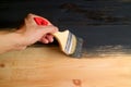 Man`s hand holding brush painting wood plank with dark grey paint Royalty Free Stock Photo