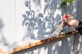 Man`s hand holding a brush and paints over the rusty construction with gray paint. Royalty Free Stock Photo