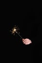 Man`s hand holding burning sparkler on a black background Royalty Free Stock Photo