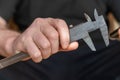 A man`s hand holding a caliper. An adult man with a high-precision metal instrument for measuring the external and internal Royalty Free Stock Photo