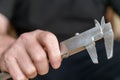 A man`s hand holding a caliper. An adult man with a high-precision metal instrument for measuring the external and internal Royalty Free Stock Photo