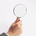 Man`s hand, holding classic styled magnifying glass, closeup isolated on white background Royalty Free Stock Photo