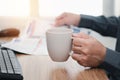 Man's hand holding coffee cup and reading a newspaper break time of working Royalty Free Stock Photo