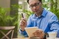 Man`s hand holding credit card with tablet for shopping online concept, selective focus and vintage tone. Royalty Free Stock Photo