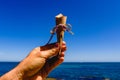 Man`s hand holding an empty paper cone facing the sea Royalty Free Stock Photo