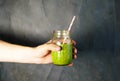 Man`s hand holding a glass jar with berry smoothie on the white wall background. Royalty Free Stock Photo