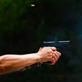 Man`s hand holding gun with dark background Royalty Free Stock Photo