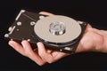Man's hand holding a hard drive taken apart