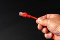 Man& x27;s hand holding internet cable on black background Royalty Free Stock Photo