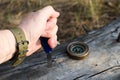 Man`s hand holding knife, compass on old log in the forest.Survival in forest, going on vacation to forest.