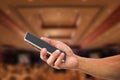 Man`s hand holding mobile phone on blurred hotel lobby Royalty Free Stock Photo