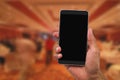 Man`s hand holding mobile phone on blurred hotel lobby Royalty Free Stock Photo
