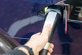 Man`s hand holding modern electric car charger outlet.