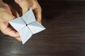 The man`s hand is holding a paper that predicts the fate known as Paper Fortune Tellers. To predict the future, work, love, fate,