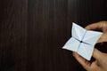 The man`s hand is holding a paper that predicts the fate known as Paper Fortune Tellers. To predict the future, work, love, fate,