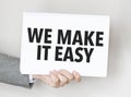 man\'s hand holding paper sheet with we make it easy words Royalty Free Stock Photo