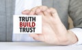 man's hand holding paper sheet with truth build trust words