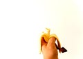 Man`s hand holding a peeled banana with a bite Royalty Free Stock Photo