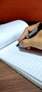 Man`s hand holding a pen writing his signature Royalty Free Stock Photo