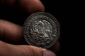 Man's hand holding a silver American coin, close-up of a quarter dollar coin isolated over black. Bag, dollars Royalty Free Stock Photo