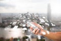 Man`s hand holding smartphone with radial blurred business icon on blurred city background