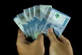 man's hand holding on some 50000 rupiah indonesian currency on solid black background Royalty Free Stock Photo
