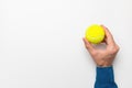 Man& x27;s hand holding a tennis ball on a white background, space for advertising Royalty Free Stock Photo