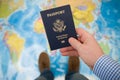 Man`s hand holding US passport. Map background. Ready for traveling. Open world Royalty Free Stock Photo