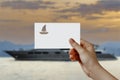 Man's hand holding Yacht symbol paper in front of sea. Concept of journey, travel, dream, freedom.