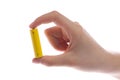 man's hand holding a yellow battery or battery on a white background isolated.