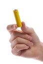 man's hand holding a yellow battery or battery on a white background isolated.