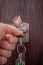 A man& x27;s hand holds a bunch of keys and inserts the key into the keyhole of the door. Vertical photo Royalty Free Stock Photo