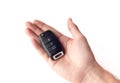 A man's hand holds the car key isolated on a white background close up. Royalty Free Stock Photo