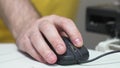 A man's hand holds a computer mouse with confidence and dexterity.