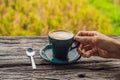 A man`s hand holds a cup of coffee on the background of an old wooden table A heart for coffee. St. Valentine`s Day Royalty Free Stock Photo