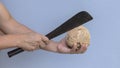 The man`s hand holds the Etoile knife and the other holds the shelled coconut. Showing coconut cutting to make coconut milk Thai