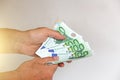 The man`s hand holds the 100 euro, considers them and pays. Pape Royalty Free Stock Photo